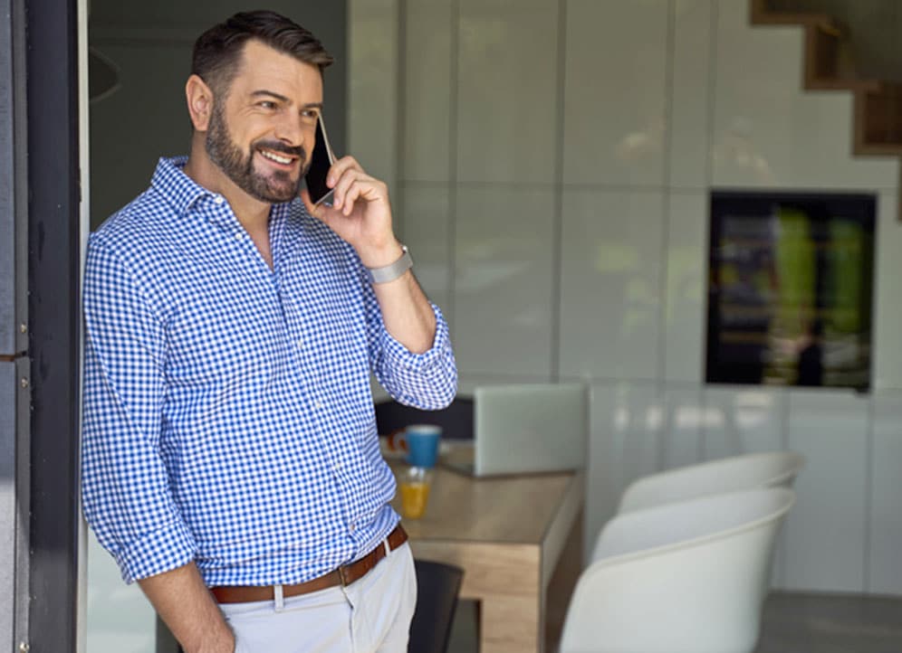Real estate agent standing by patio door talking to client on phone