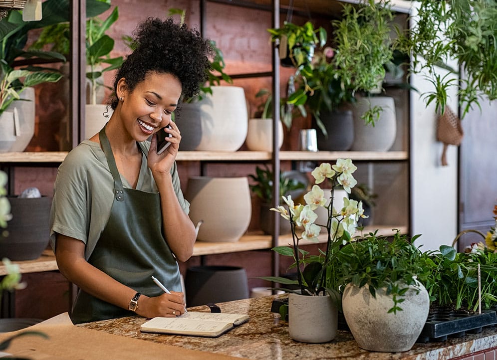 Woman taking customer order over phone in small business