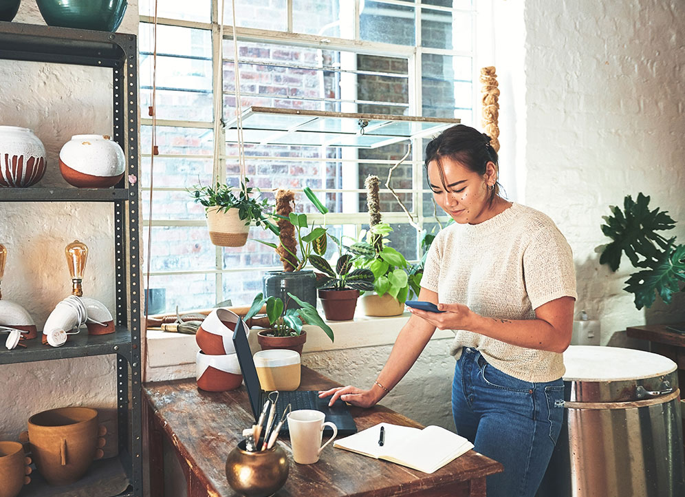 Woman at startup reception desk looking at text message from customer