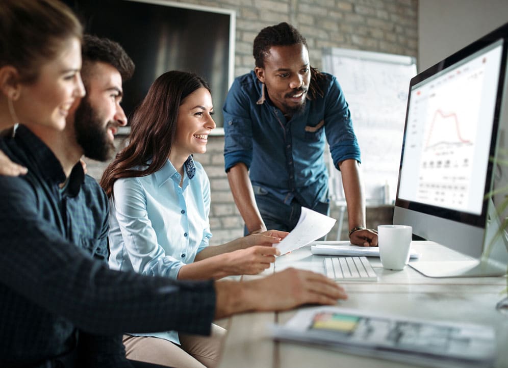 Coworkers at startup looking at monitor with Tresta web app