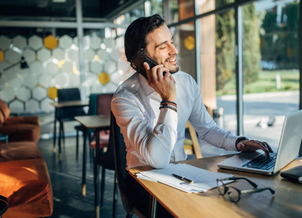 Man in co-working space talking to colleague about startup business