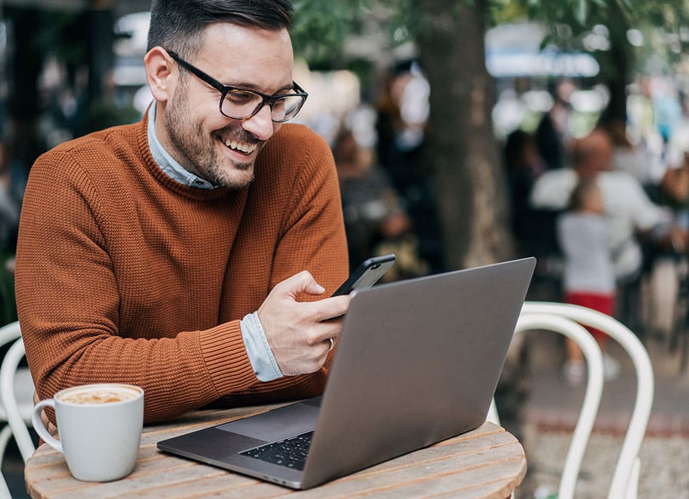 Businessman working at laptop in outdoor cafe 2