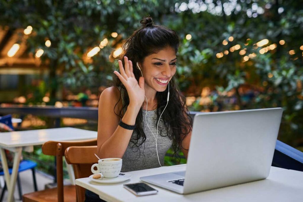 Woman on conference call on laptop outdoors