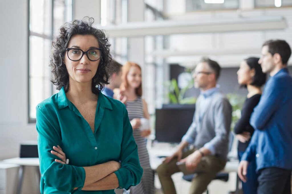 Woman standing in front of team in office